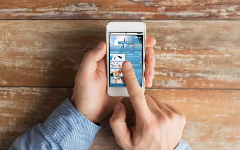 An overhead view of a thumb reaching across a phone screen