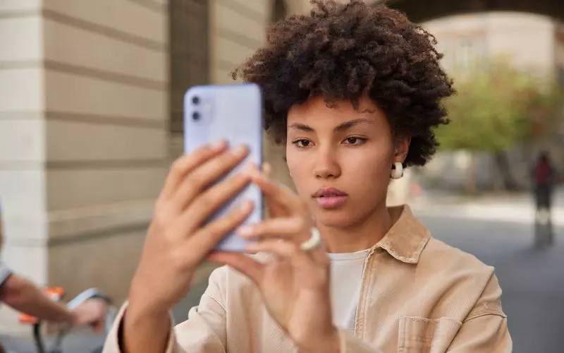 Someone taking a photograph with their phone outdoors