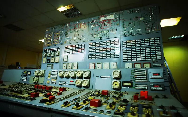 A wall of dials and switches on a control panel