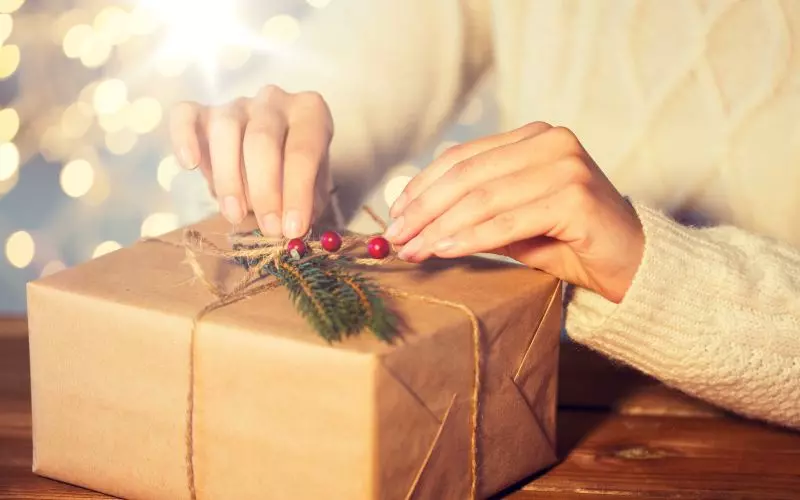 Hands tying a brown paper parcel