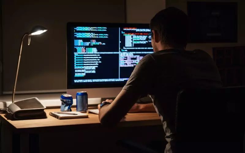 A developer at monitors showing code