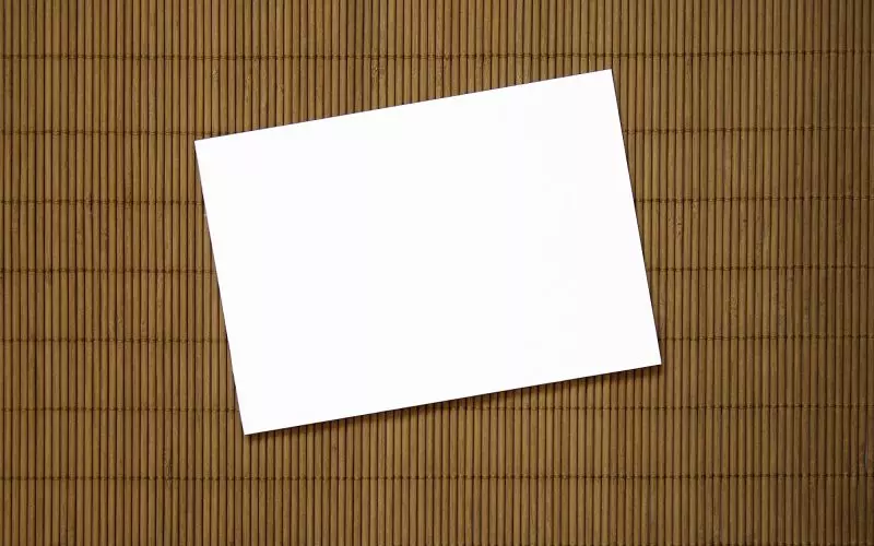 A plain white card on a woven mat