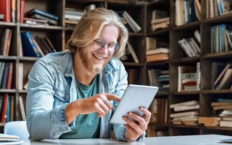Someone browsing on a tablet in a library