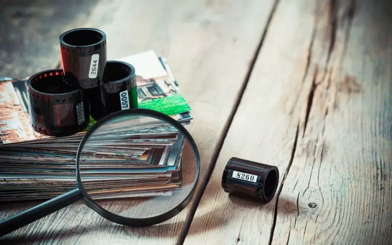 Film canisters and a loupe on a wooden desk