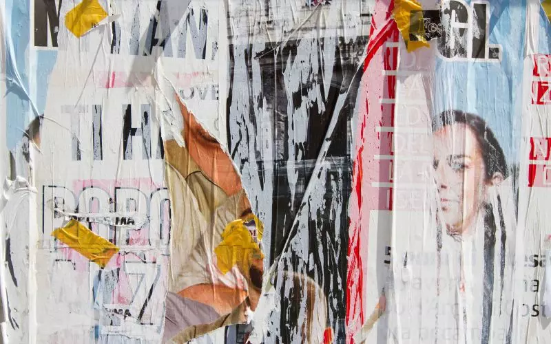 A wall of layered, weathered posters