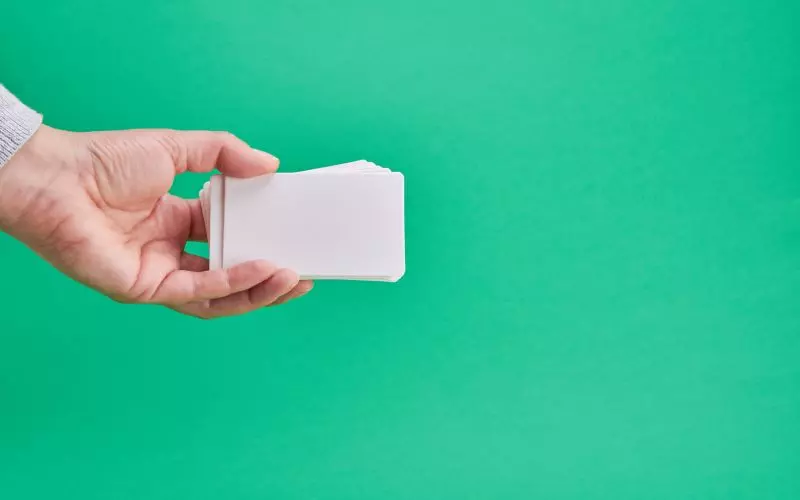 A hand holding a blank white card