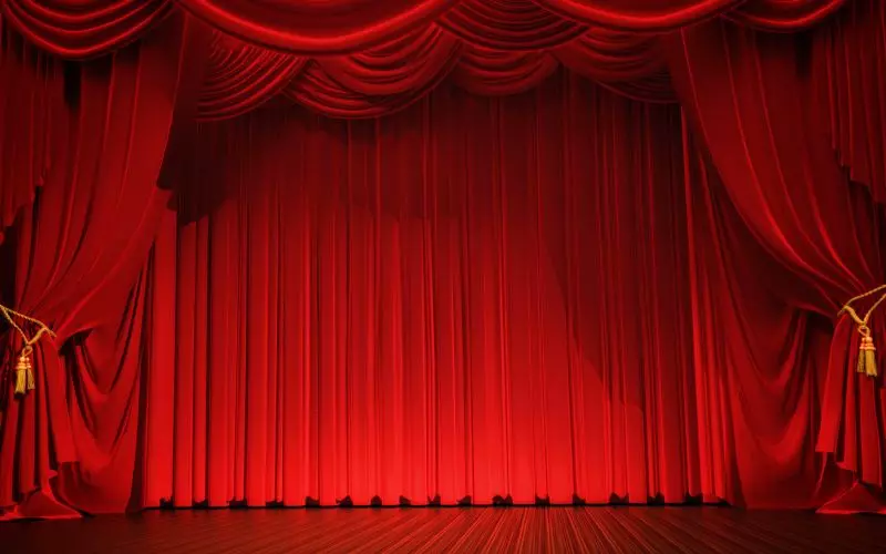 A closed red theater curtain with a gold valance