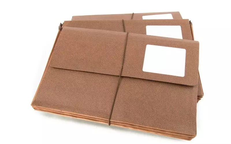 A stack of file folders with blank white labels
