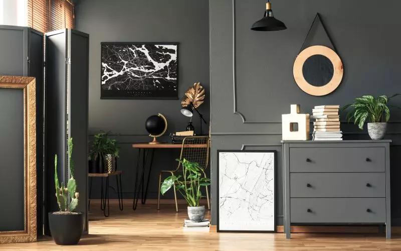 A round gold mirror on a dark interior wall