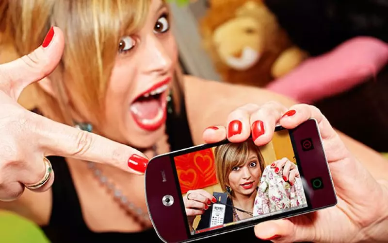 A woman looking shocked at her phone