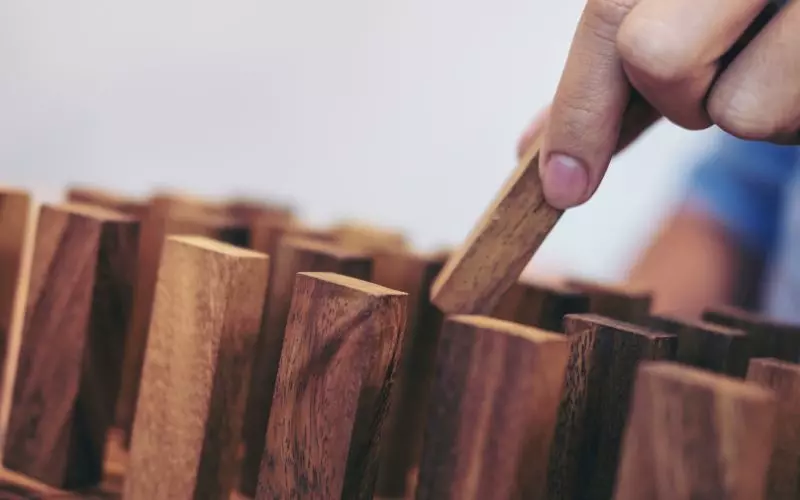 A hand moving one wooden block in a row
