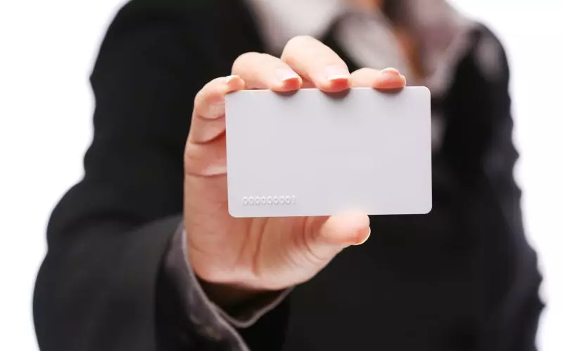 A hand holding up a blank business card