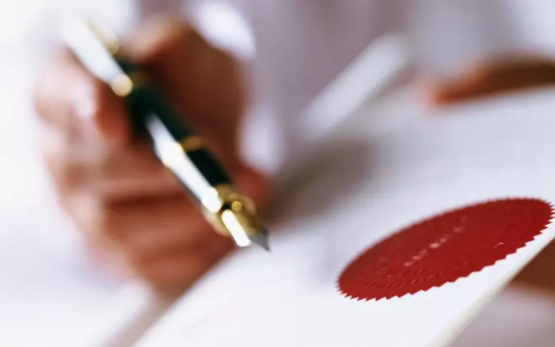 A pen and an embossed seal on a document