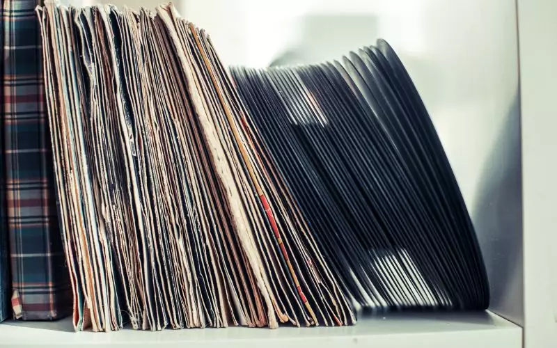 A row of vinyl records filed upright in their sleeves