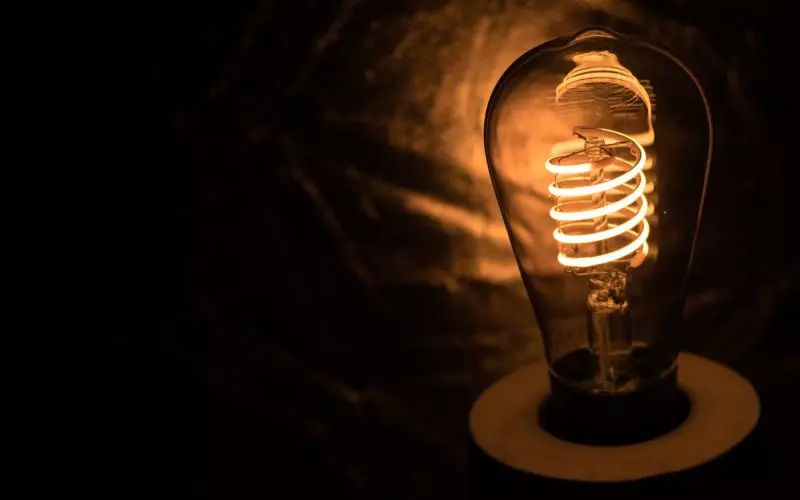 A single filament bulb glowing in the dark