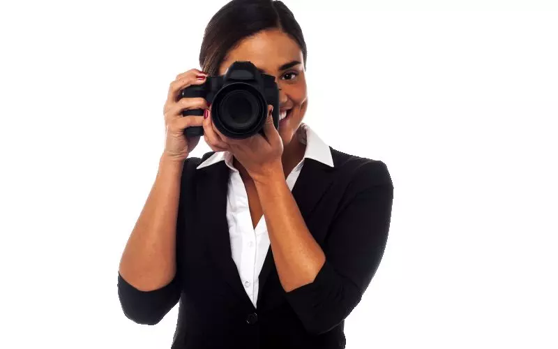 A photographer holding a camera up to her eye