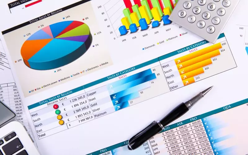 Printed charts and graphs laid out on a desk