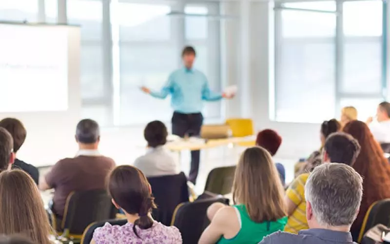 A speaker addressing a seated audience