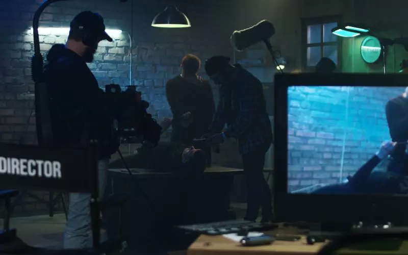 A film crew at monitors on a set at night
