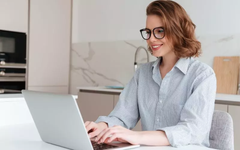 A woman working at a laptop in a bright office