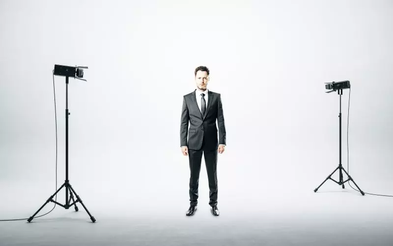 A man being photographed between two studio lights