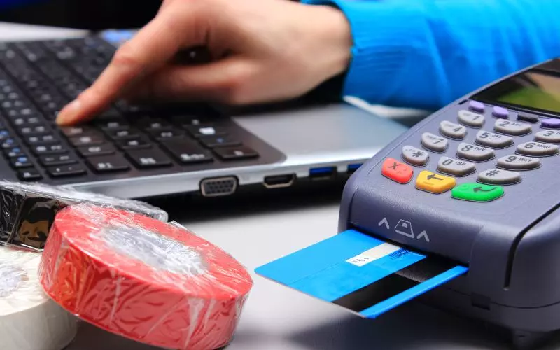 A card being used at a payment terminal on a desk