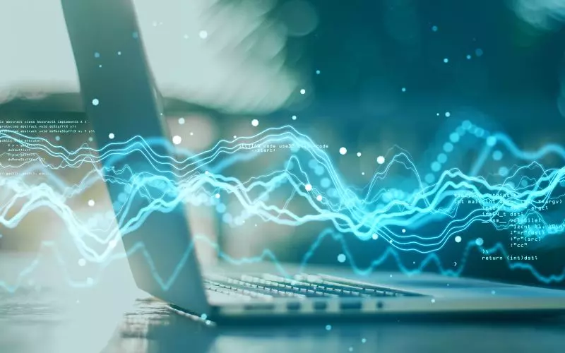 A laptop showing a glowing sound wave