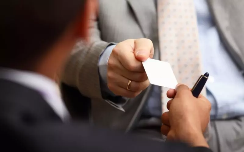 One person handing a card to another