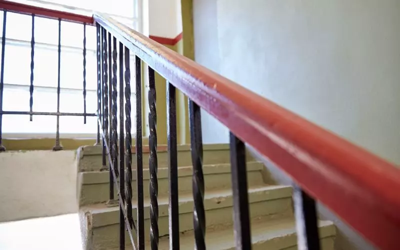 A red handrail running alongside a staircase