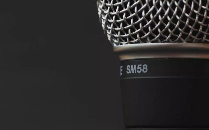A studio microphone against a dark ground